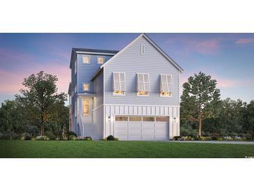 Charming exterior of a home with light blue siding, a two-car garage, and a well-manicured lawn at 512 9Th Ave. S, North Myrtle Beach, SC 29582