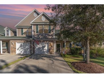 Charming two-story home with a two-car garage and well-maintained landscaping and green shutters at 611 Indigo Bunting Ln. # 42 E, Murrells Inlet, SC 29576