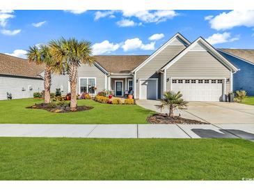 Charming single-story home featuring a well-manicured lawn, landscaped flower beds, and a two-car garage at 7205 Spoleto Dr., Myrtle Beach, SC 29572