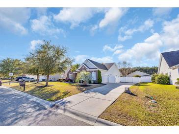 Beautiful one-story home with a manicured lawn, mature trees, and a welcoming driveway at 133 Hartwell Dr., Little River, SC 29566