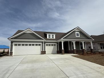 Charming single-Gathering home featuring a 3 car garage, gray siding, and a welcoming front porch at 246 River Edge Dr., Myrtle Beach, SC 29588