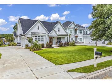 Stunning, two-story home with a lush lawn, manicured landscaping, and a concrete driveway leading to a spacious three-car garage at 1121 Glossy Ibis Dr., Conway, SC 29526