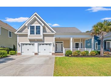 Charming home featuring a welcoming front porch, manicured lawn, and a two-car garage at 1127 East Isle Of Palms Ave., Myrtle Beach, SC 29579