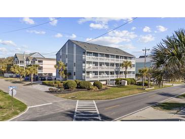 Condo building with three stories and multiple balconies, surrounded by palm trees at 1210 N Ocean Blvd. # 105, Surfside Beach, SC 29575
