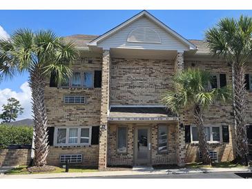 Inviting brick condominium exterior featuring palm trees and well-maintained landscaping at 218 Double Eagle Dr., Surfside Beach, SC 29575