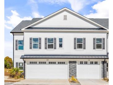 Inviting exterior showcasing a modern two-story townhome with white siding, gray shutters, and individual garages at 305 Lineback Pl. # 33, Longs, SC 29568