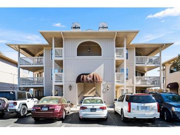 Inviting condo exterior with covered balconies, neutral tones, and ample parking, offering a glimpse of comfortable living at 4234 Pinehurst Circle # L1, Little River, SC 29566