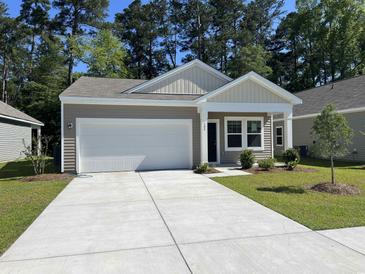 Charming single-story home with attached garage, well-manicured lawn, and mature trees at 639 Muster Field Ct., Conway, SC 29526