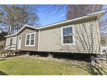 Exterior of home with beige siding, white trim, a small porch, and visible underpinning at 909 Pine Thicket St., Myrtle Beach, SC 29577