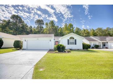 Charming single-story home featuring a manicured lawn, attached garage, and a vibrant red front door at 1161 Ganton Way, Myrtle Beach, SC 29588