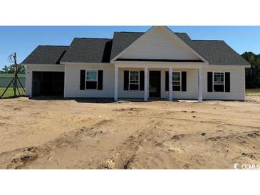 New construction home features a charming white exterior, black shutters, and an attached two-car garage at 1284 Highway 45, Loris, SC 29569