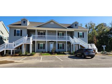Attractive, two-story condo with gray siding, white trim, dormer windows, and inviting staircases leading to elevated porches at 1415 Gooseneck Place # 101, Murrells Inlet, SC 29576