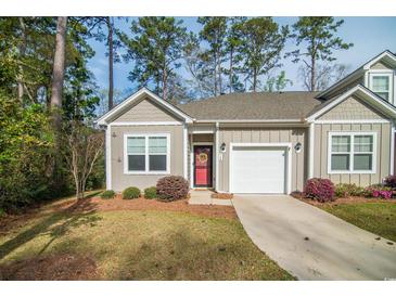 Charming single-story home with a red door, attached garage, and a well-maintained lawn surrounded by mature trees at 164 Vineyard Place # 23, Pawleys Island, SC 29585