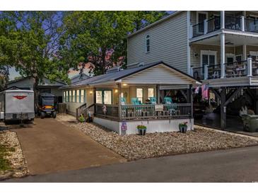 Charming single-story home with a covered porch and a driveway with a trailer parked outside at 6001 - 5010 S Kings Hwy., Myrtle Beach, SC 29575