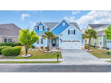 Charming blue two-story home with a well-manicured lawn, palm trees, and a two car garage at 6004 Flowerdale Ct., Myrtle Beach, SC 29579