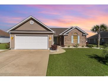 Charming single-story home with a two-car garage, brick accents, and lush green lawn at 621 Swinford Dr., Myrtle Beach, SC 29588