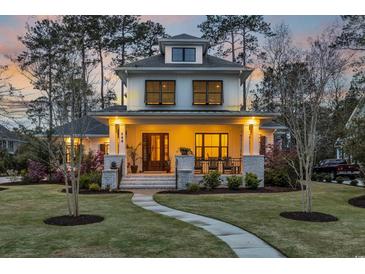 Charming two-story home with inviting front porch, manicured lawn, and beautiful landscaping at 644 Whispering Pines Ct., Murrells Inlet, SC 29576