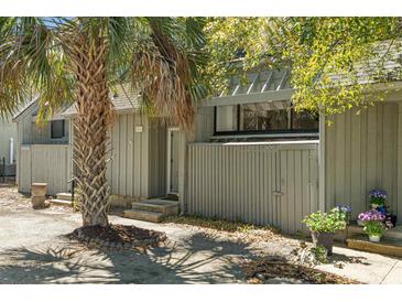 Charming gray home exterior featuring a mature palm tree and lovely landscaping at 7300 Porcher Dr. # 11, Myrtle Beach, SC 29572