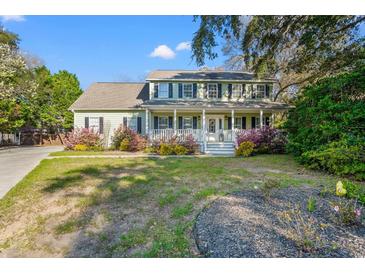 Charming home with a welcoming front porch, a well-maintained lawn, and mature landscaping at 837 Flicker Pl., Murrells Inlet, SC 29576