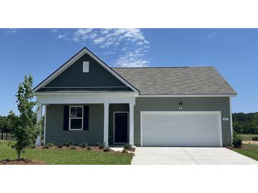 Charming single-story home with a well-manicured lawn, a two-car garage, and lovely curb appeal at 886 Farmers Passage Loop, Loris, SC 29569