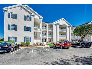 Three-story condo building featuring white siding, blue shutters, and private balconies with parking at 901 West Port Dr. # 2101, North Myrtle Beach, SC 29582