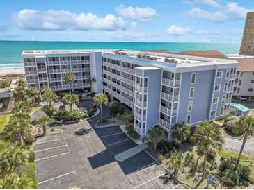 Spacious condo building featuring palm trees, a large parking lot, and ocean views at 9580 Shore Dr. # 311, Myrtle Beach, SC 29572