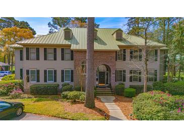 Two-story home with brick and siding exterior, landscaped front yard, and well manicured yard at 110-4 White Tail Way # 4, Pawleys Island, SC 29585