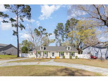 Charming single story home featuring a spacious front yard, rocking chair porch, and inviting curb appeal at 150 Brookgate Dr., Myrtle Beach, SC 29579