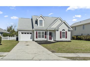 Charming home showcasing a well-manicured lawn, attached garage, and lovely curb appeal at 2633 Corn Pile Rd., Myrtle Beach, SC 29588