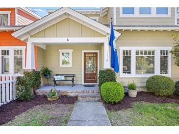 Inviting front porch with bench, manicured landscaping, and charming South Carolina flag at 381 Da Gullah Way # 8 B, Pawleys Island, SC 29585