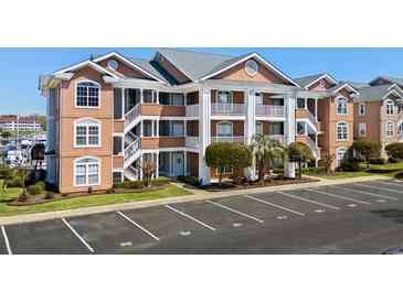 Attractive condo exterior with well-maintained landscaping and parking at 4633 Lightkeepers Way # 5H, Little River, SC 29566