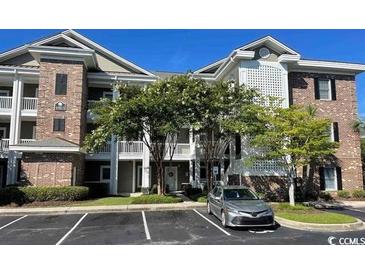 Attractive condominium exterior with well-maintained landscaping and ample parking at 4865 Magnolia Pointe Ln. # 204, Myrtle Beach, SC 29577