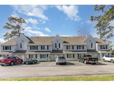 Three-story condo building featuring gray siding and multiple cars in the parking lot in front at 500 Fairway Village Dr. # 5D, Myrtle Beach, SC 29588