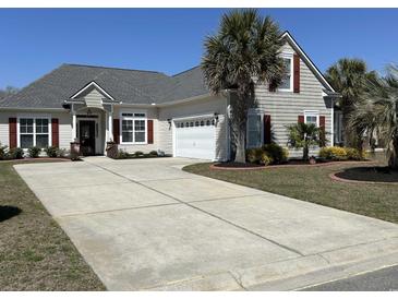 Charming home featuring a long driveway, two-car garage, palm trees and complementary dark-red window shutters at 59 Willowbend Dr., Murrells Inlet, SC 29576