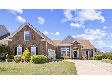 Charming brick home featuring a manicured lawn and inviting curb appeal on a sunny day at 324 Highfield Loop, Myrtle Beach, SC 29579