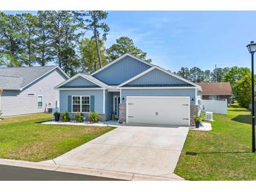 Charming single-story home with a two-car garage, blue siding, manicured lawn, and tasteful landscaping at 361 Rycola Circle, Myrtle Beach, SC 29575