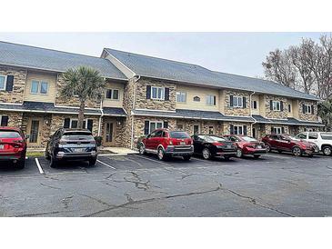 Charming townhome featuring manicured landscaping, brick accents, and convenient parking at 200 Double Eagle Dr. # D3, Surfside Beach, SC 29575
