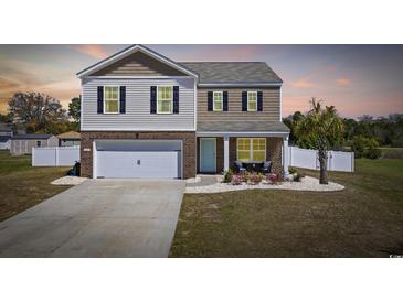 Charming two-story home with a well-manicured lawn, brick accents, and a cozy front porch at 206 Math Place, Longs, SC 29568
