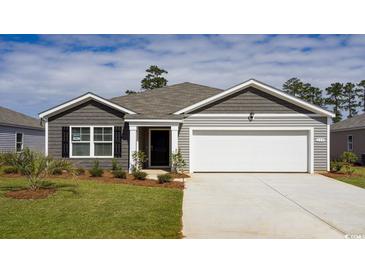 Charming single-story home with gray siding, a two-car garage, and a well-manicured lawn and landscaping at 124 Ashworth Dr., Tabor City, NC 28463