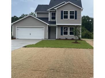 Charming two-story home featuring a gray exterior with a white garage door and a well-manicured lawn at 1490 Hardwick Rd., Conway, SC 29526
