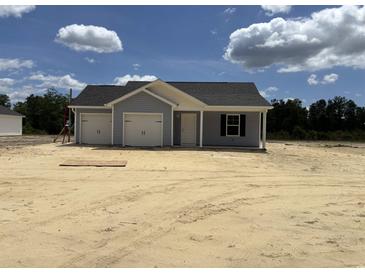 Charming single-story home with a two-car garage, light blue siding, and a well-manicured lawn at 1502 Hardwick Rd., Conway, SC 29526
