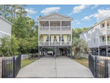 Inviting two-story coastal home features a stilt foundation, and charming double porches at 3704 Chapel Ln., Myrtle Beach, SC 29588