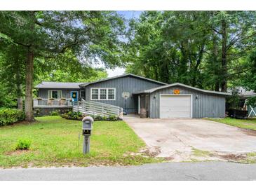 Charming single Gathering home with front porch, garage, blue door, and a well-maintained lawn at 532 Medcalf Dr. Sw, Sunset Beach, NC 28468