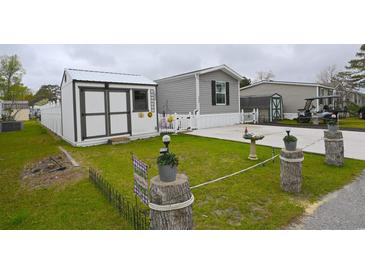 Charming mobile home featuring a storage shed, well-maintained yard, and a cozy, welcoming atmosphere at 1525 Capella Ln., Myrtle Beach, SC 29575
