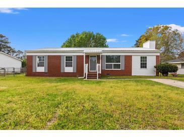 Charming single-story home with brick and vinyl siding, a metal roof, a well-maintained lawn, and gray shutters at 1287 Stalvey Ave., Myrtle Beach, SC 29577