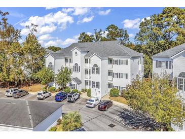 Three-story condominium building featuring classic white facade and ample parking at 1525 Lanterns Rest Rd. # 304, Myrtle Beach, SC 29579