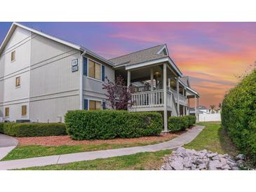 Condo exterior featuring a covered porch, lush landscaping, and a sidewalk leading to the entrance at 1860 Auburn Ln. # 19E, Surfside Beach, SC 29575