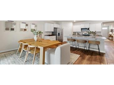 Bright eat-in kitchen featuring stainless steel appliances, granite countertops, and a breakfast bar at 478 Blissful Ln., Little River, SC 29566