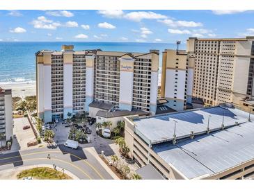 Beautiful aerial view of a light beige beachfront condominium with a parking deck, the beach, and the blue ocean at 4800 S Ocean Blvd. # 1103, North Myrtle Beach, SC 29582