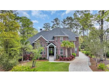 Beautiful brick two-story home featuring professional landscaping and a paved driveway at 653 Whispering Pines Ct., Murrells Inlet, SC 29576